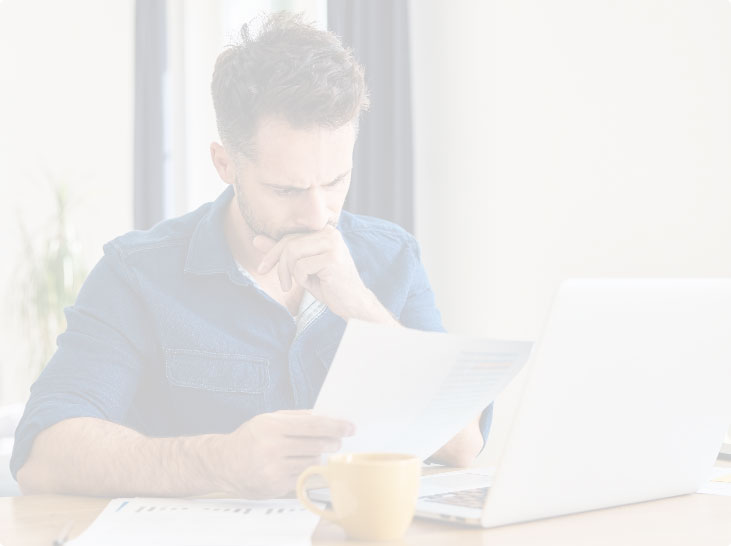 Man reviewing papers at comptuer